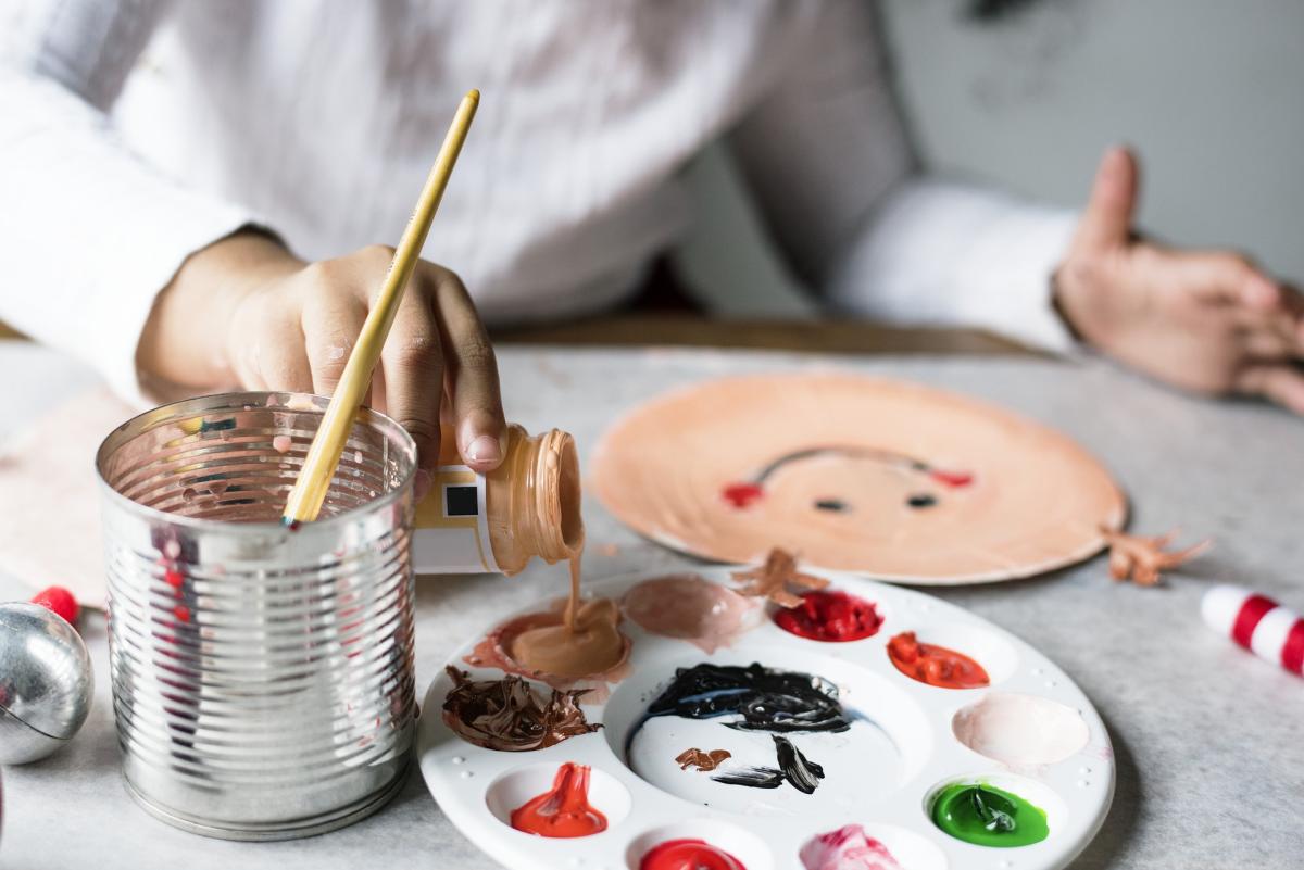 Child pouring more paint into her paint palette